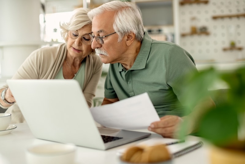 senior couple analyzing their savings while going through home finances